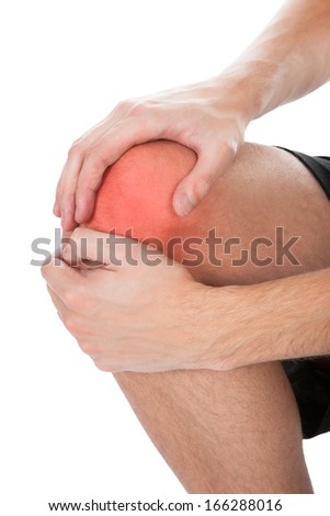 Close-up Of Man Suffering From Knee Injury On White Background