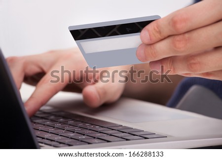 Person Holding Credit Card And Shopping Online Using Laptop