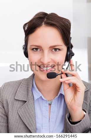 Portrait Of Happy Young Female Telephone Operator With Headphones