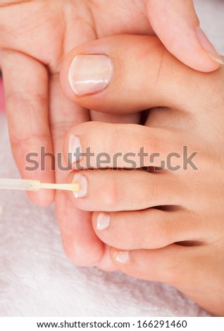 Close-up Of A Beautician Applying Nail Varnish To Woman\'s Feet