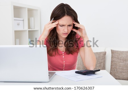 Portrait Of A Worried Young Woman Doing Calculations