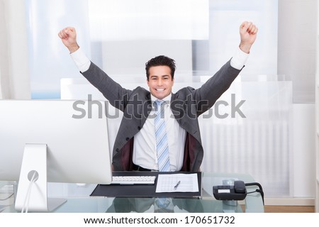 Excited Young Businessman Raising His Hands In Joy
