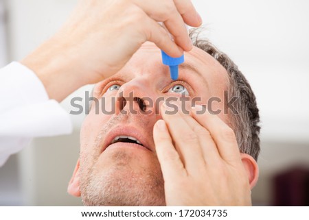 Close-up Of A Mature Man Putting Eye Drops In Eyes