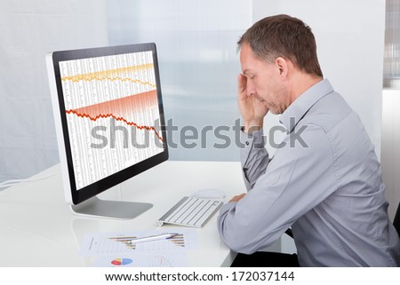 Portrait Of Mature Tired Businessman Sitting In Office