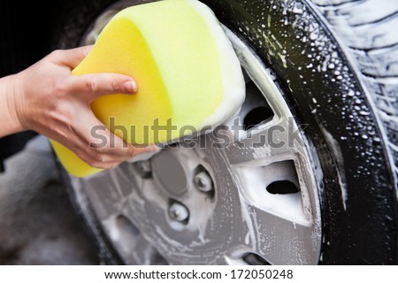 Close-up Of Hand Washing A Tire With Sponge