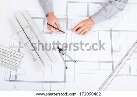 Close-Up Of Person\'S Hand Drawing Plan On Blue Print