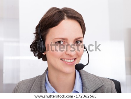 Portrait Of Happy Young Female Telephone Operator With Headphones