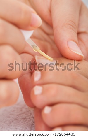 Close-up Of A Beautician\'s Hand Applying Nail Varnish To Woman\'s Feet