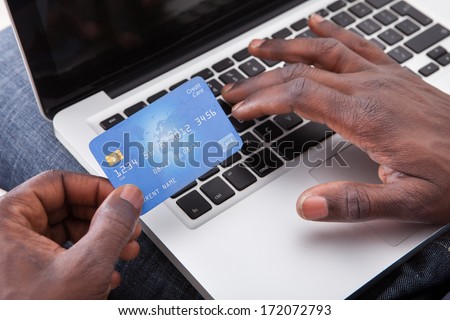 Close-Up Of Hand Holding Credit Card And Shopping Online