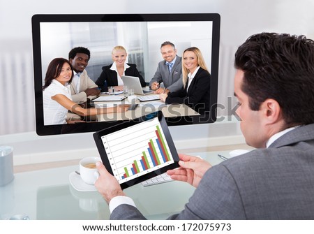 Young Businessman Analyzing Graph While Chatting With His Colleagues