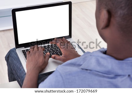 Close-up Of African Man Typing On Laptop