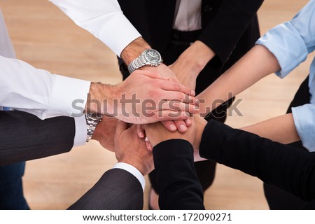 Close-up Of Businesspeople Putting Their Hands On Top Of Each Other