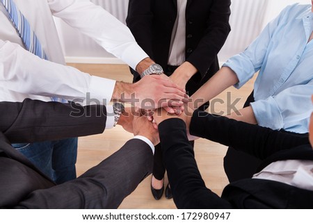 Close-Up Of Businesspeople Putting Their Hands On Top Of Each Other