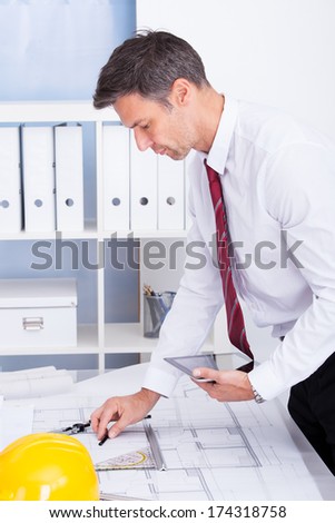 Portrait Of Male Architect Drawing Blueprint Using Digital Tablet