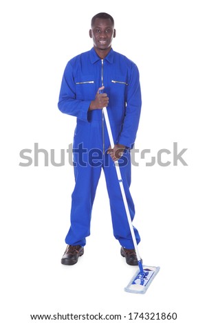 Young Man In Blue Boiler Suit Holding Mop Over White Background