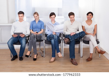 Group Of People Sitting On Chair In A Waiting Room