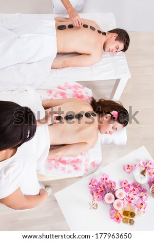 Beautiful Young Couple Having A Stone Massage In A Spa Center