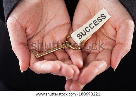 Close-up Of Hand Holding Golden Key In Hand