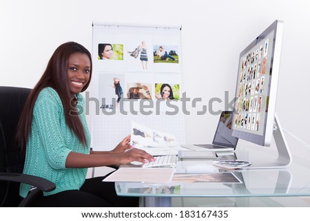 Young female editor using digital tablet at photo agency