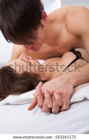 Lusty young couple having prelude in bed at home