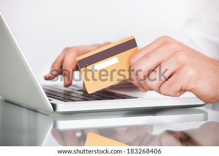 Cropped image of man shopping with credit card and laptop