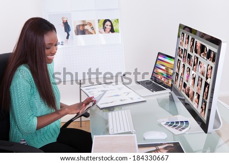 Young female editor using digital tablet at photo agency
