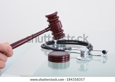 Judges gavel and a stethoscope in a conceptual image of a judgment in a medical malpractice claim