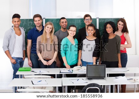 Group portrait of confident multiethnic college students standing together in classroom