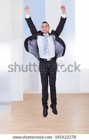 Full length portrait of successful businessman in office