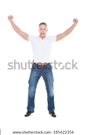 Handsome man cheering in exultation punching the air with his fists as he celebrates good news  full length isolated on white