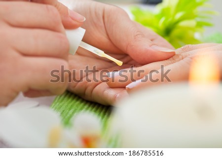 Closeup View Of A Beautician\'s Hand Applying Nail Varnish To Woman\'s Hand