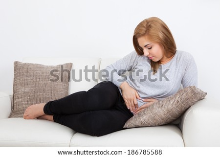 Portrait Of Young Woman With Pain In Her Stomach