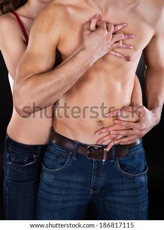 Young woman seducing man isolated over black background