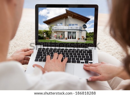 Couple Looking At House On Laptop\'s Screen