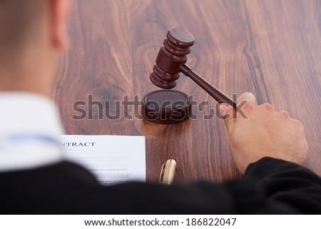 Cropped image of judge knocking gavel in courtroom