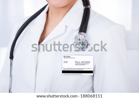 Midsection of female doctor with ID card and stethoscope