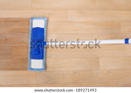 Directly above shot of maid cleaning hardwood floor with mop
