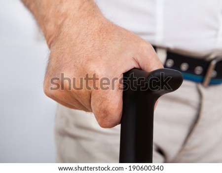 Midsection closeup of disabled senior man with walking stick