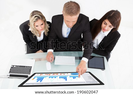 High angle view of businesspeople using desktop PC together at desk in office