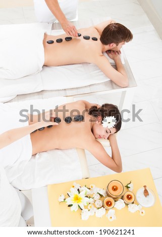 High angle view of couple receiving Lastone therapy at beauty spa