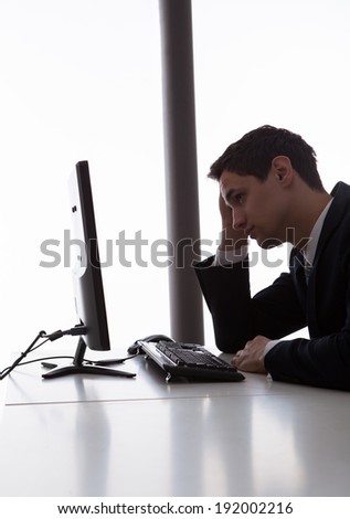 Side view of worried businessman looking at computer in office