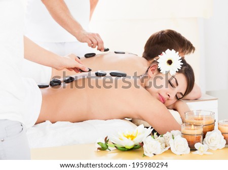 Young couple receiving Lastone therapy at beauty spa