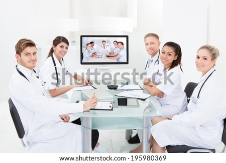 Team of doctors attending video conference at desk in hospital