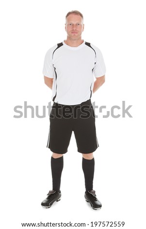 Full length portrait of mid adult man in sportswear standing hands behind back over white background