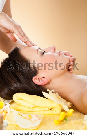 Side view of young woman receiving head massage in spa