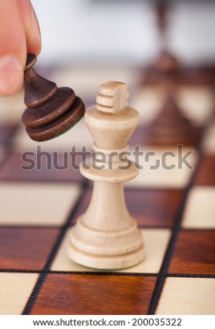 Cropped image of woman\'s hand playing chess on table