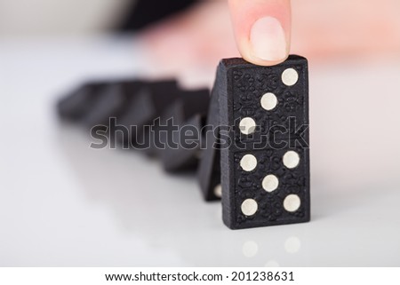 Cropped image of woman\'s hand playing domino on table