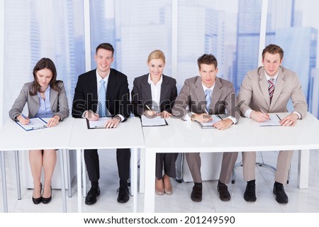Panel of corporate personnel officers sitting at table for taking interview