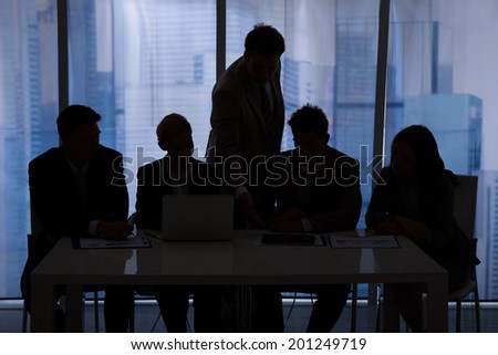Silhouette of businessmen and businesswomen discussing in office