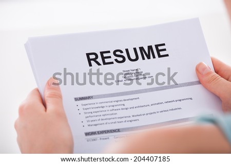 Cropped image of young woman holding resume over white background